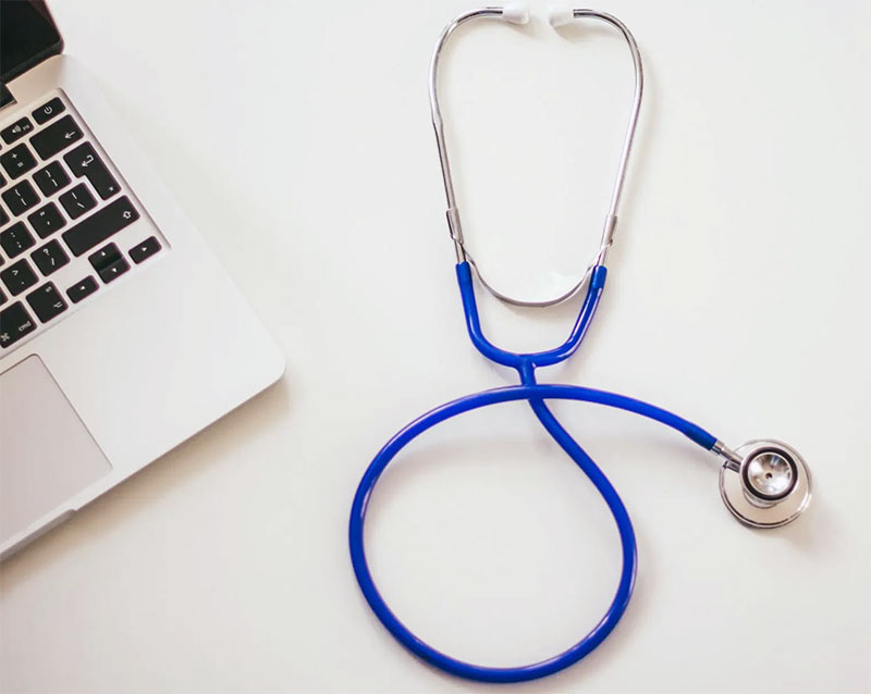 stethoscope and laptop on white tabletop